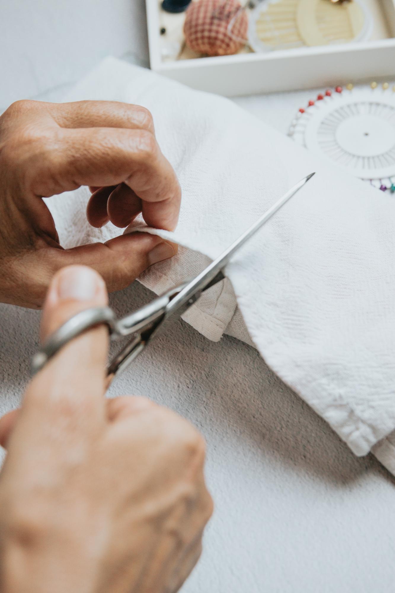 Artisan embroiderer hands working on linen